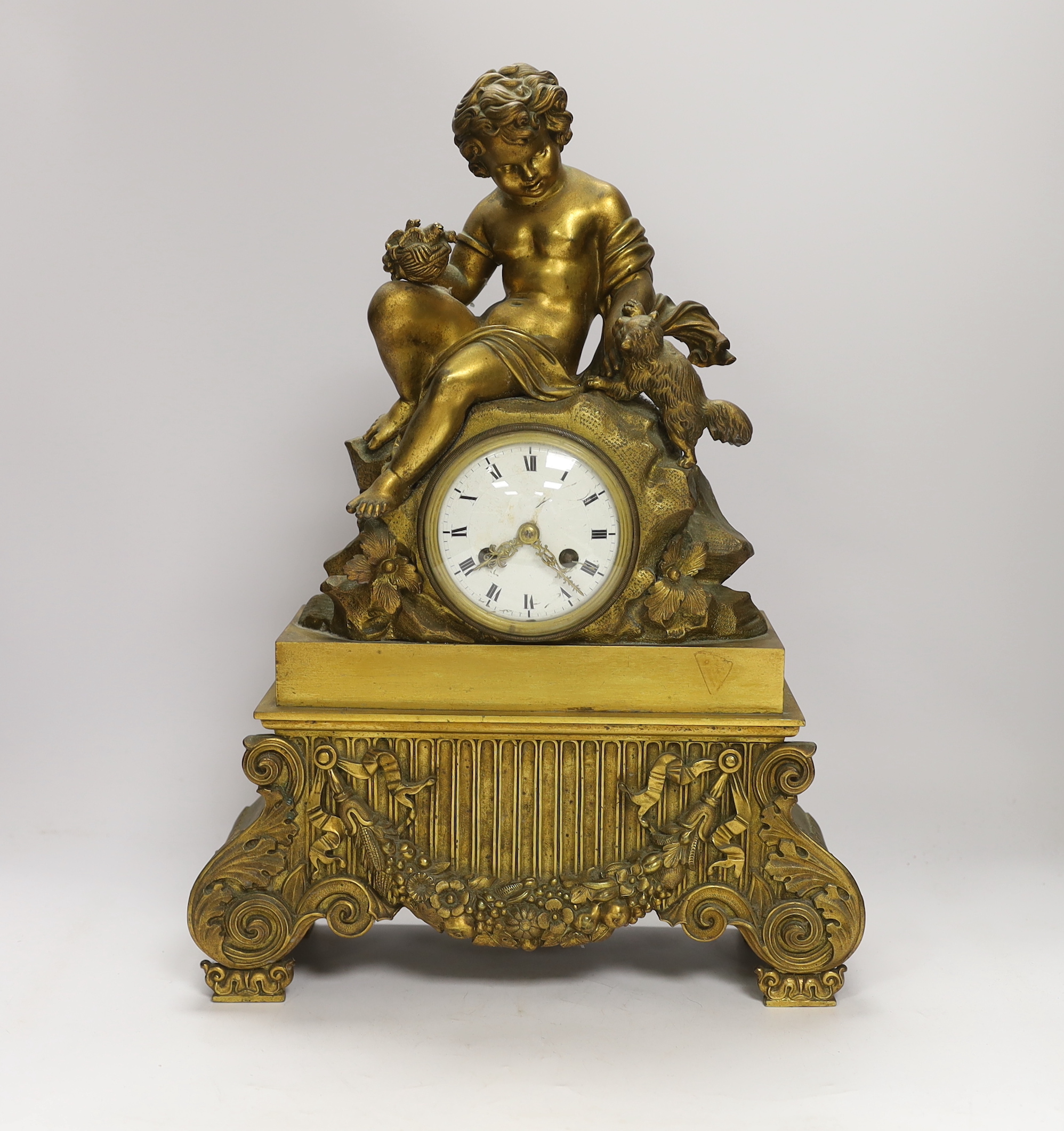 A decorative French ormolu mantel clock, the top a child playing with a kitten and the base with scrolled feet below a swag of flowers, 42cm high